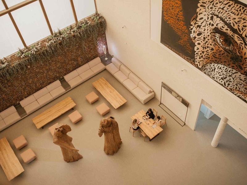 Innenbereich mit minimalistischen Holzmöbeln, drei Bärenfiguren und großem Leopardenbild an der Wand.