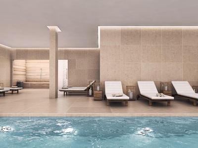 Moderner Innenpool mit blauen Wasser, weißen Liegen und hellen Steinfliesen an den Wänden.