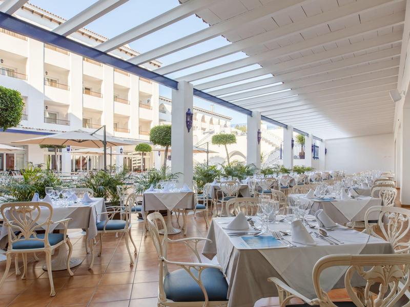 Hell überdachte Terrasse mit gedeckten Tischen und Stühlen in elegantem Restaurantambiente.