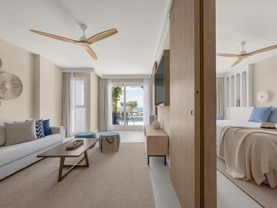 Helles modernes Apartment mit Wohnzimmer, Schlafzimmer, Deckenventilatoren und Balkon mit Meerblick.