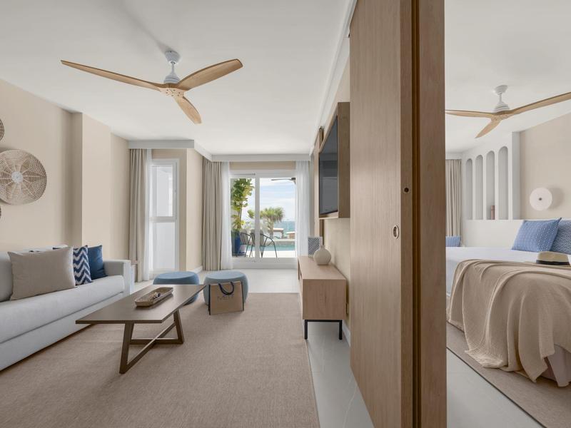 Helles modernes Apartment mit Wohnzimmer, Schlafzimmer, Deckenventilatoren und Balkon mit Meerblick.