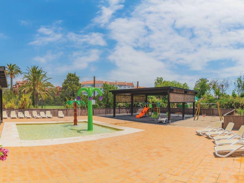Outdoor-Wasserpark mit Wasserspielen und Liegestühlen unter blauem Himmel