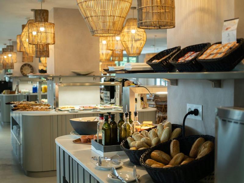 Hell beleuchteter Frühstücksbereich mit frischem Brot und dekorativen Lampen in modernem Stil.