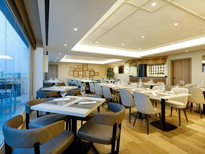 Modernes Restaurant mit gedeckten Tischen und Holzfußboden in hellem Interieur.