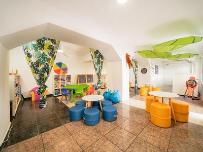 Moderner, farbenfroher Kinderspielraum in einem Hotel mit Sitzgelegenheiten und Spielzeug.