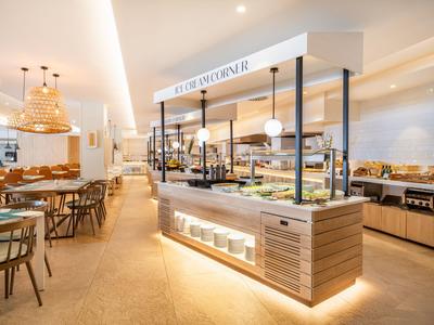 Moderner Frühstücksbereich mit Buffet und hellem, einladendem Ambiente in einem Hotel.