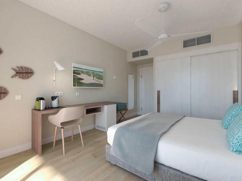 Helles Schlafzimmer mit großem Bett, Schreibtisch, Stühlen, weißer Schiebetür und Wanddekoration.