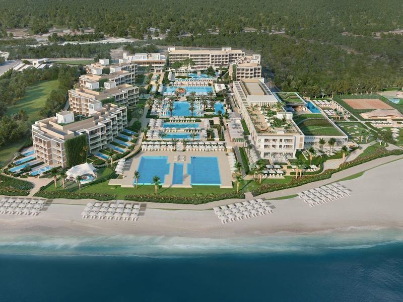 Ein Mann schlägt Golfball auf einem grünen Golfplatz mit Palmen im Hintergrund.