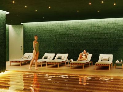 Innenraum eines Spabereichs mit Holzliegen, dunkelgrünen Wänden und warmem Lichtschein.