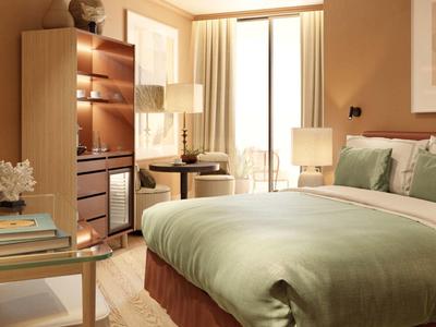 Gemütliches Schlafzimmer mit grünem Bett, Holzregal, kleinem Tisch und warmem Licht.