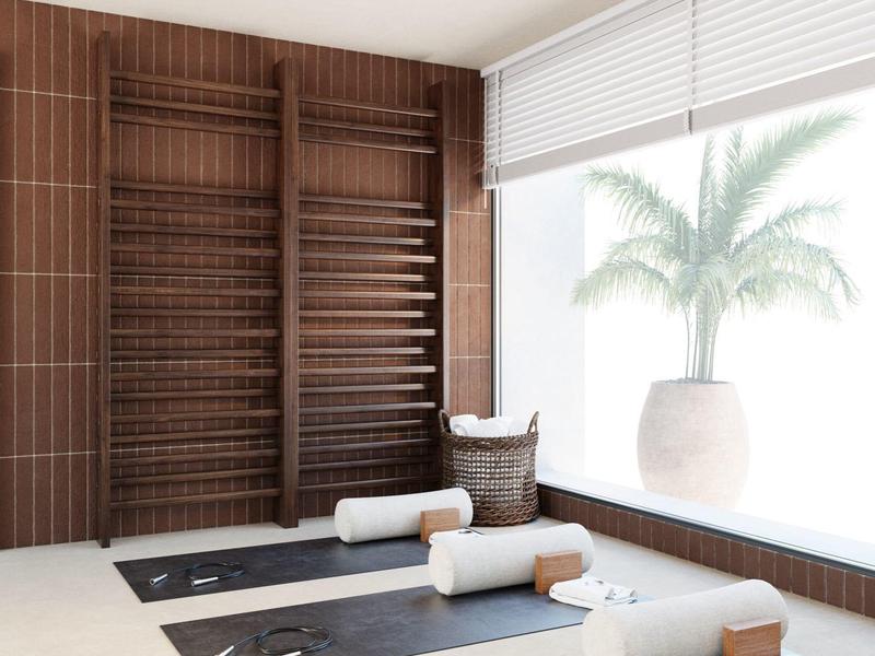 Moderner Yogaraum mit drei Matten, weißen Handtüchern und großen Fenstern mit Pflanzenblick.