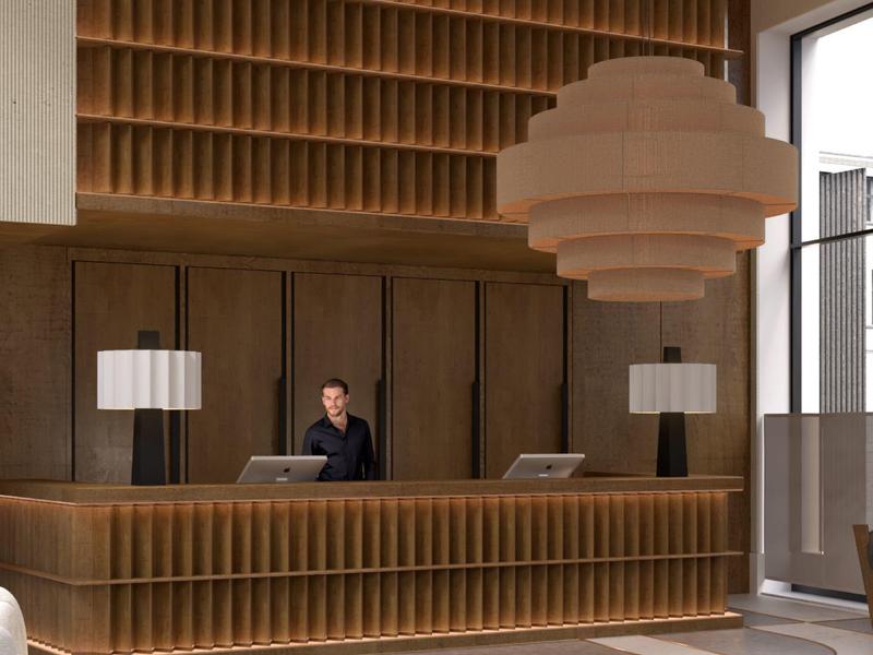 Moderner Empfangsbereich mit hölzernem Tresen, zwei Lampen und großem hängendem Leuchter.