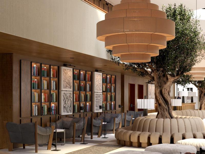 Moderner Innenraum mit Baum und runder Holzlichtinstallation, Sitzbänken und Büchern an der Wand.