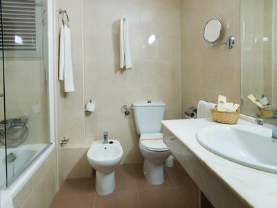 Modernes Badezimmer mit Dusche, Toilette, Bidet und Waschbecken mit Spiegel.