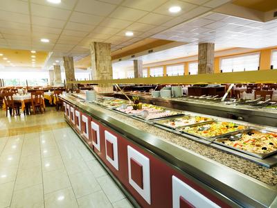 Buffetbereich in einem Hotel mit vielfältigen Speisen auf langen Theken und vielen Sitzplätzen.