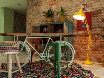 Modern interior with metal table, colorful rug, and brick wall with bookshelf