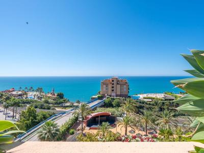 Blick auf eine Küstenstadt mit Palmen und einem Hotel unter blauem Himmel und Meer
