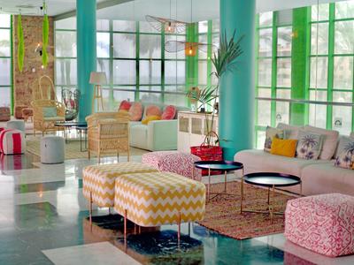 Helle, moderne Hotellobby mit bunten Sitzmöbeln und großen Fenstern.