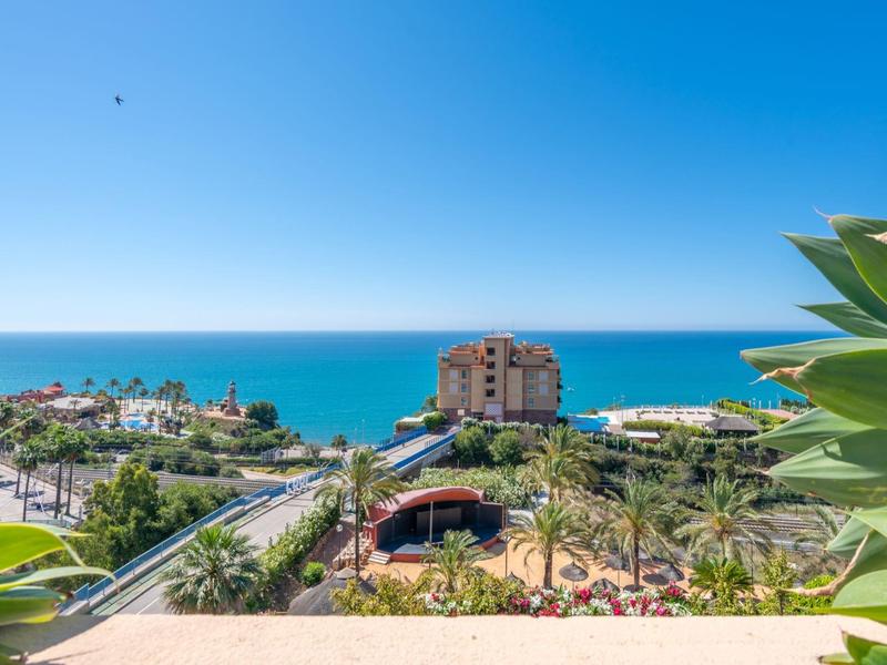 Blick auf eine Küstenstadt mit Palmen und einem Hotel unter blauem Himmel und Meer
