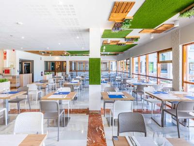 Helle, moderne Kantine mit vielen Tischen, Stühlen und großen Fenstern für viel Tageslicht.