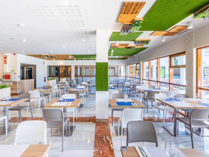 Helle, moderne Kantine mit vielen Tischen, Stühlen und großen Fenstern für viel Tageslicht.