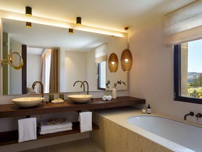 Moderne Badezimmer mit Doppelwaschbecken, großem Spiegel, Badewanne und warmem Licht in neutralen Tönen.