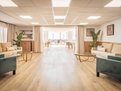 Heller, moderner Hotel-Warteraum mit Sofas, Sesseln und Holzfußboden.