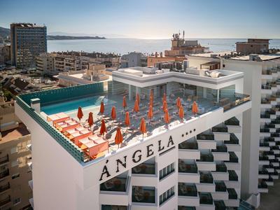 Dachterrasse mit orangenen Sonnenschirmen und Liegestühlen, Meerblick im Hintergrund.