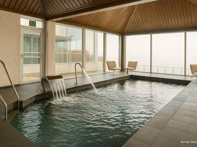 Una piscina interna moderna con cascata e grandi finestre con vista sulla città.