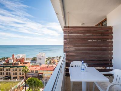 Balkon mit Tisch, Stühlen und Meerblick in einem Hotel an der Küste.