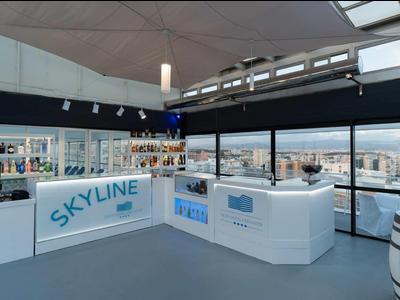 Nowoczesna recepcja w jasnej, otwartej przestrzeni hotelowej z panoramicznym widokiem i marką Skyline.