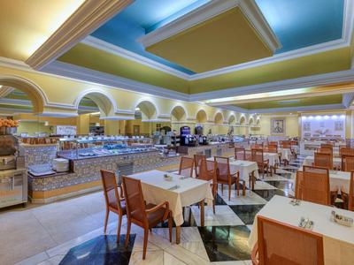 Ampia sala da pranzo con tavoli e buffet sotto soffitto a volta blu