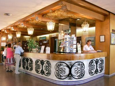 Hotelbar mit hölzernem Tresen und kundennahen Gästen in warm beleuchtetem Raum.