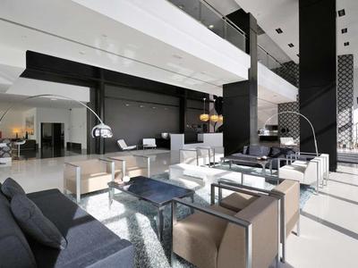 Moderne Hotellobby mit schwarzen, weißen und beigen Möbeln und großen Fenstern