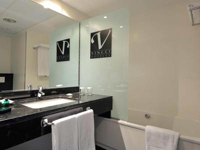 Moderner Hotelbadezimmer mit schwarzen Arbeitsplatten, Badewanne und Handtüchern