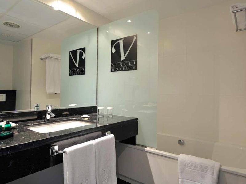 Sauberes Badezimmer mit schwarzer Waschplatte, Spiegel, Badewanne und hellen Wänden.