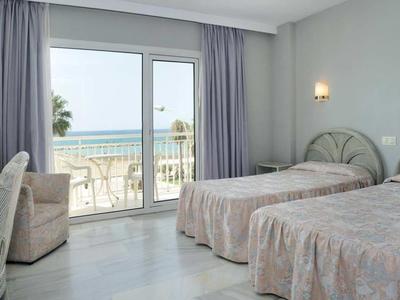 Hotelzimmer mit zwei Einzelbetten und Balkon mit Meerblick