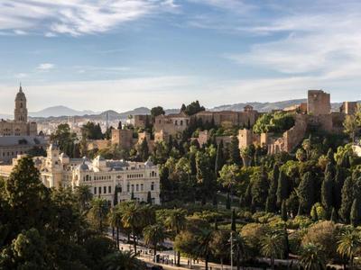 Blick auf eine historische Stadt mit Bergen im Hintergrund bei klarem Himmel.