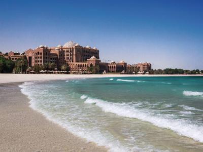 Ein großes Hotel am Strand mit klarem blauen Himmel und sanften Wellen.