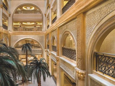 Luxuriöses Hotelinterieur mit goldenen Verzierungen und Palmen.