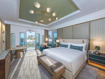 Elegantes Hotelzimmer mit großem Bett, Balkon und Meerblick.