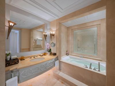 Luxuriöses Badezimmer mit Badewanne, Doppelwaschbecken und großem Spiegel.