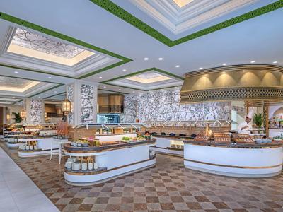 Moderner Hotel-Speisesaal mit Buffet, Holzdecke und gemütlicher Beleuchtung.