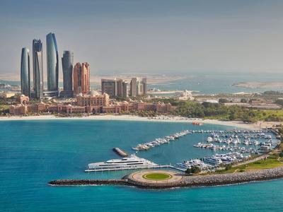 Panoramablick auf Yachthafen mit Wolkenkratzern und Küstenlinie bei klarem Himmel.