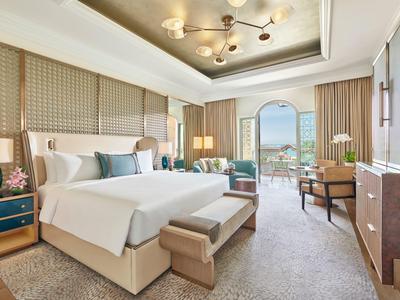 Elegantes Hotelzimmer mit Doppelbett, Sitzbereich und weitem Blick durch Panorama-Fenster.