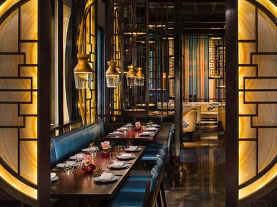 Elegantes Restaurant mit runden, beleuchteten Türen und gedeckten Tischen in warmem Licht