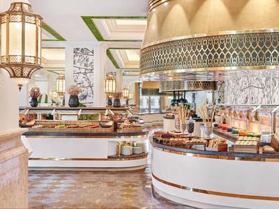 Eleganter Frühstücksbuffetbereich in einem Hotel mit warmem Licht und modernem Design.