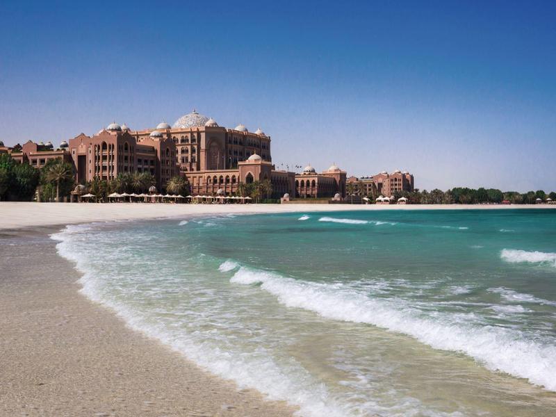 Ein großes Hotel am Strand mit klarem blauen Himmel und sanften Wellen.