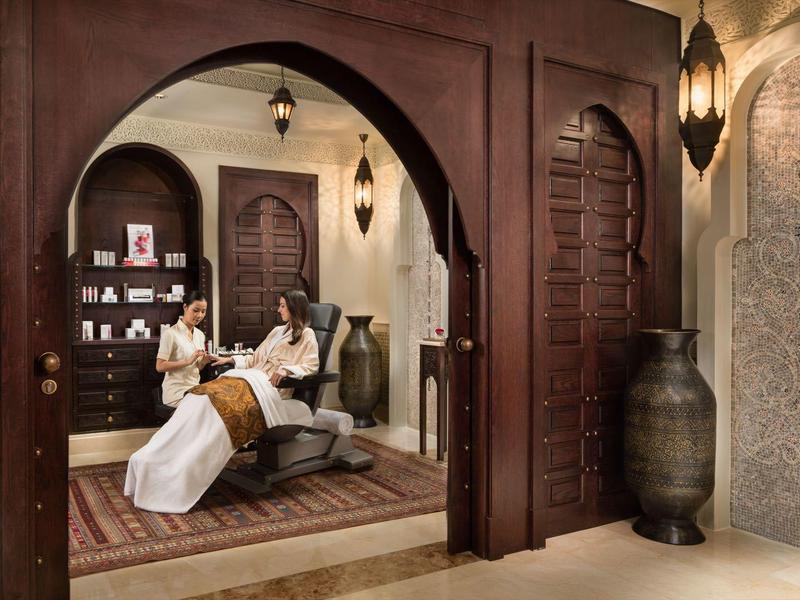 Luxuriöses Interieur mit traditionellen Ornamenten und komfortabler Sitzgruppe in warmem Licht.