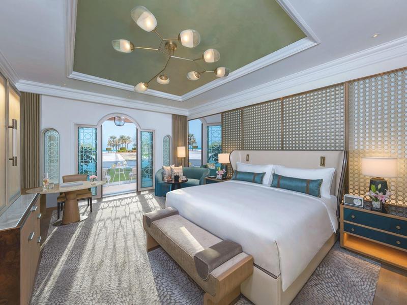 Elegantes Hotelzimmer mit großem Bett, Balkon und Meerblick.